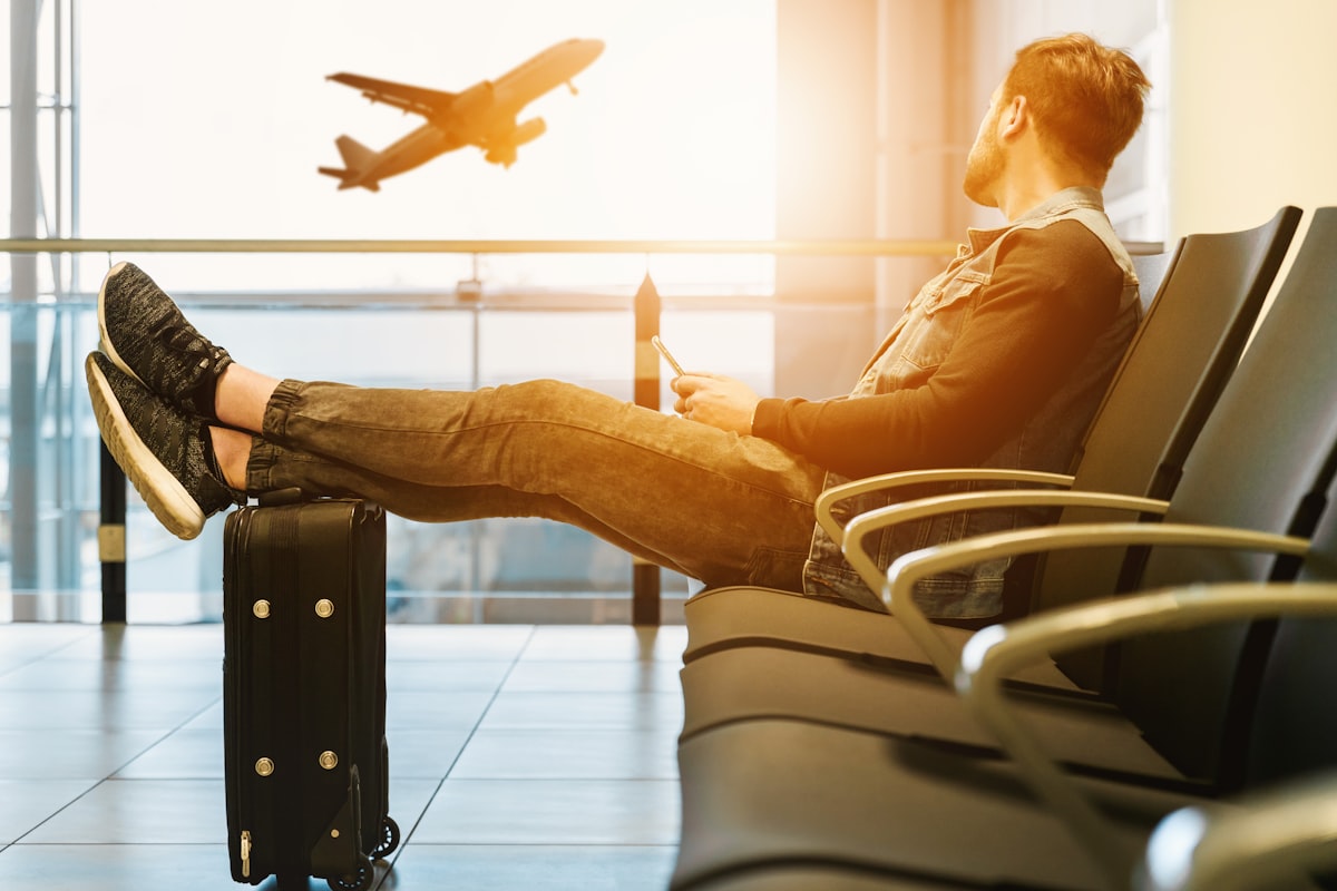 Traveler waiting in an airport lounge with carry-on luggage